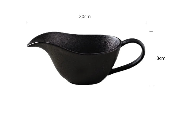 Curtis Ceramic Gravy Boat by Allthingscurated features an easy-to-hold handle and a narrow spout to ensure precise pouring without spills and drips. Available in white with a smooth, shiny glaze or black with a matte, rough finish. This versatile serveware with a capacity of 220ml or 7.4 fluid ounce is perfect for any occasion, formal or casual.