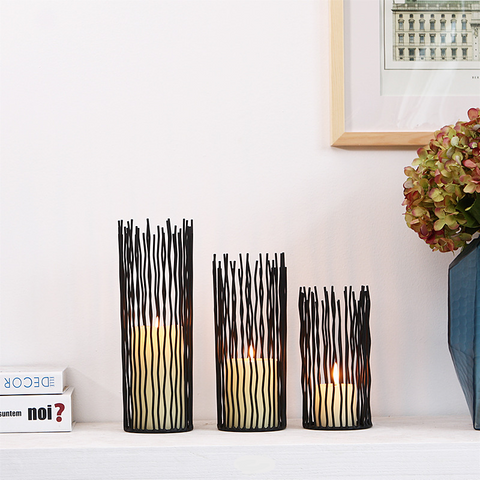 Estel Black Wire Candle Holders by Allthingscurated have openwork pattern that resembles willow-like branches in a cylindrical arrangement.  Crafted from iron and in black finish, these candle holders come in 3 sizes.