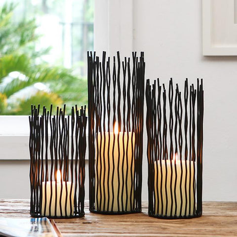Estel Black Wire Candle Holders by Allthingscurated have openwork pattern that resembles willow-like branches in a cylindrical arrangement.  Crafted from iron and in black finish, these candle holders come in 3 sizes.