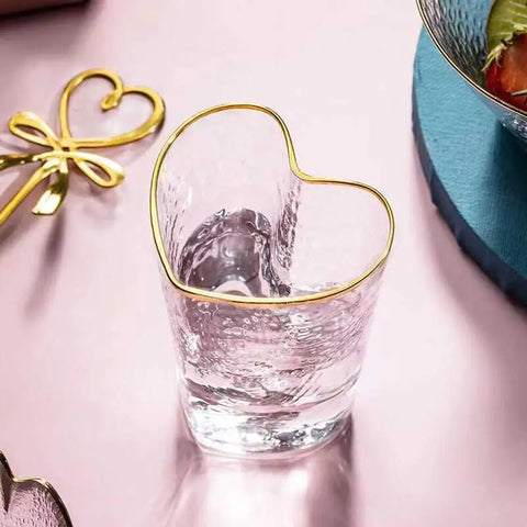 Heart Shape Tumbler by Allthingscurated is a stylish addition to any table. Made of glass and spots a unique, stylish heart-shaped design with an elegant gold rim and hammered pattern. Versatile for everyday use or as a special gift to show your love on Valentine’s Day.