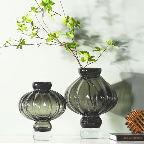 Luna Lantern Vases by Allthingscurated are stylish and versatile. Crafted from high-quality thick glass and creatively shaped like an Oriental Lantern with a strong aesthetic, they are perfect for creative floral arrangement or simply as a decorative display on its own. Comes in 2 sizes and 3 avaliable colors of green, gray and amber.