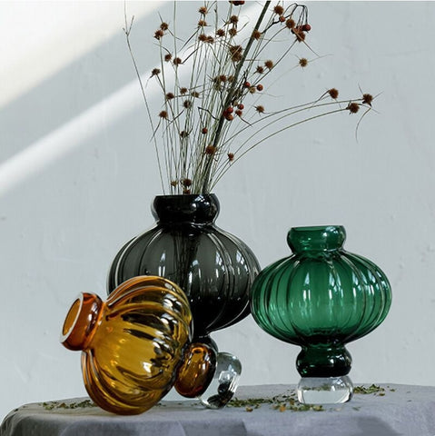 Luna Lantern Vases by Allthingscurated are stylish and versatile. Crafted from high-quality thick glass and creatively shaped like an Oriental Lantern with a strong aesthetic, they are perfect for creative floral arrangement or simply as a decorative display on its own. Comes in 2 sizes and 3 avaliable colors of green, gray and amber.