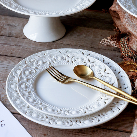 Juliette White Lace Dinnerware by Allthingscurated adds an elegant touch to your tabletop. This sophisticated set is crafted out of ceramic with a beautiful embossed lace rim, giving it a vintage touch.  The creamy white pieces come in a dinner plate and cake stand in 2 sizes for easy mixing and matching. They are perfectly sized for a main course, starters and desserts.