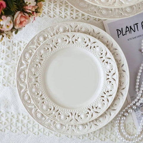 Juliette White Lace Dinnerware by Allthingscurated adds an elegant touch to your tabletop. This sophisticated set is crafted out of ceramic with a beautiful embossed lace rim, giving it a vintage touch.  The creamy white pieces come in a dinner plate and cake stand in 2 sizes for easy mixing and matching. They are perfectly sized for a main course, starters and desserts.