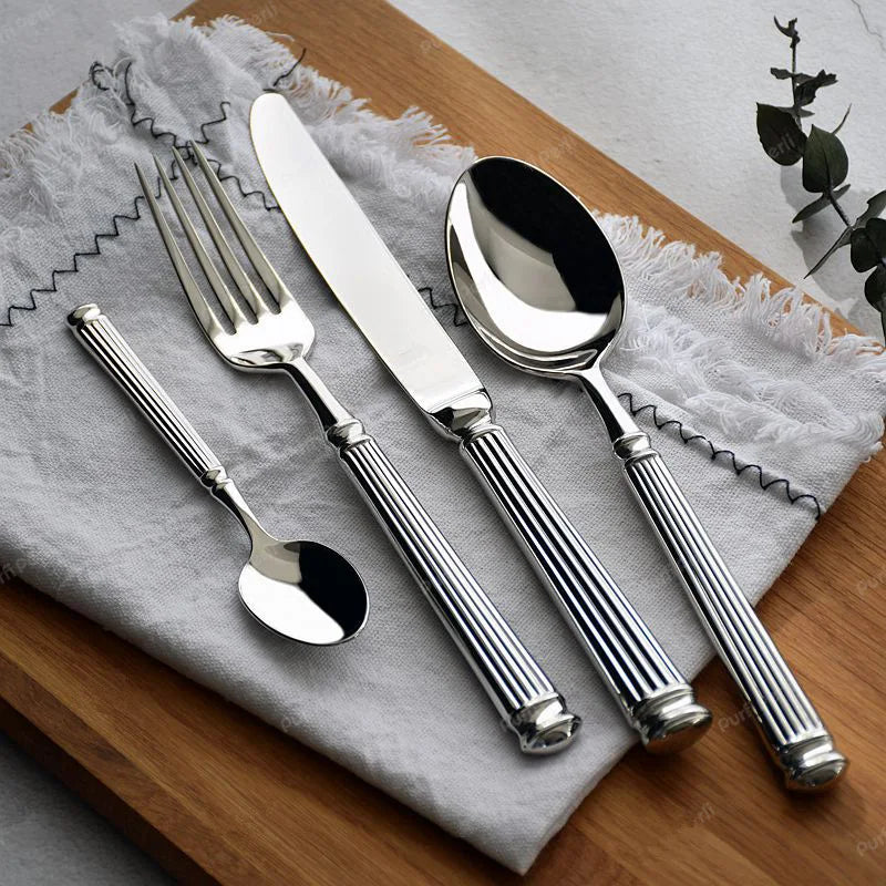 Julius Silver Stainless Steel Flatware Sets by Allthingscurated are crafted from high-quality 18/10 stainless steel. The weighty and solid construction provides a luxurious feel, while the Roman column handle design adds a touch of elegance. The mirror polished surface reflects a bright and shiny finish, adding a touch of sophistication to any table.