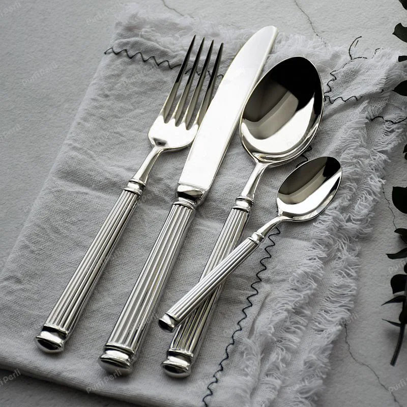 Julius Silver Stainless Steel Flatware Sets by Allthingscurated are crafted from high-quality 18/10 stainless steel. The weighty and solid construction provides a luxurious feel, while the Roman column handle design adds a touch of elegance. The mirror polished surface reflects a bright and shiny finish, adding a touch of sophistication to any table.