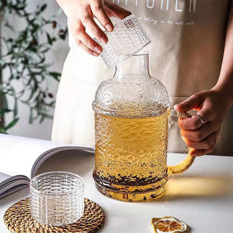 Kiv Hammered Glass Pitcher with Cover in 2 liter or 68 ounce capacity by Allthingscurated. Comes with a hemp rope handle for a rustic vibe. Large capacity and heat-resistant. It's the perfect thirst quencher for summer.