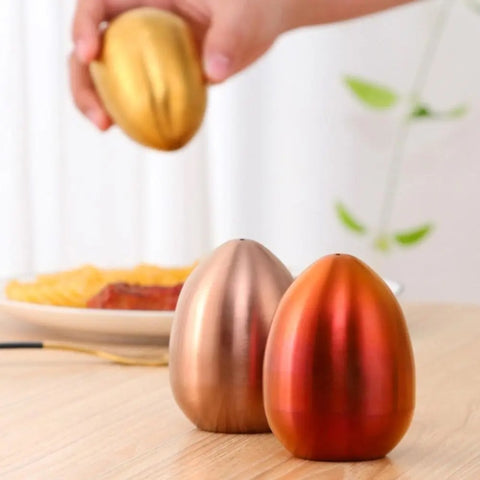 Introducing Metallic Egg Shape Salt and Pepper Shaker by Allthingscurated. This shaker is crafted from stainless steel and comes in 5 delightful colors. Perfect for Easter celebrations and as a housewarming gift. It will add a touch of playfulness to your dining table and spice up your meals with a little humor.