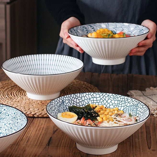 This Blue and White Japanese Ramen Bowls by Allthingscurated feature a modern, Asian design in a conical shape with a white fluted exterior, the porcelain bowls spot a beautiful, Japanese-inspired print for the interior. Comes in 4 different designs, this versatile bowl is not just for ramen, but also great for soups, curries and salads.