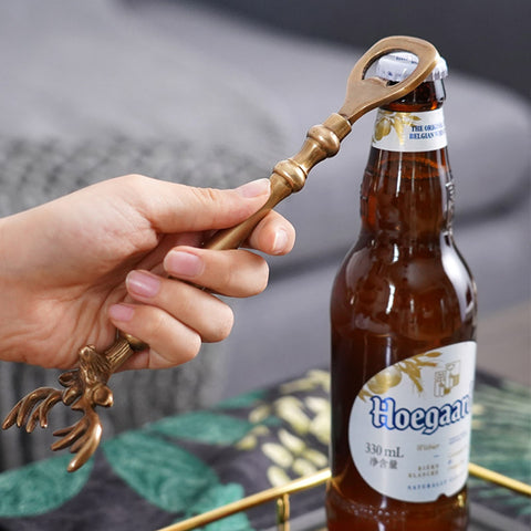 Brass Reindeer Bottle Opener by Allthingscurated.  Crafted from brass and designed with a long handle and an ornamental reindeer head—it is an eye-catching bar tool and charming accessory for Christmas and beyond.