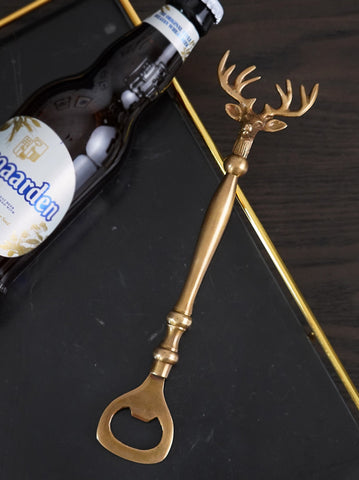 Brass Reindeer Bottle Opener by Allthingscurated.  Crafted from brass and designed with a long handle and an ornamental reindeer head—it is an eye-catching bar tool and charming accessory for Christmas and beyond.