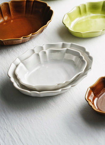 French Style Ruffle Edge Dish by Allthingscurated are oval shallow serving dishes featuring a ruffle edge with curved rims. Come in 3 colors of white, green and brown and in 2 sizes.