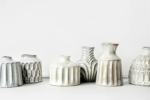 Kiara Stoneware Vases by Allthingscurated is a collection of small ceramic vases with a rustic beauty. Comes in various shapes and sizes with beautiful details and etched patterns. Off-white in color in 5 designs.
