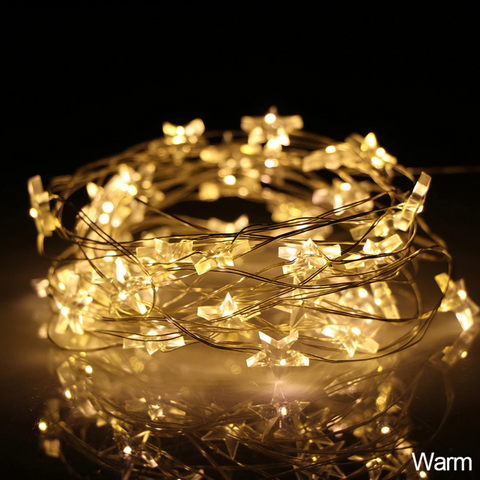 Mini Stars LED Fairy Lights by Althingscurated. Create a cozy and festive atmosphere with these decorative lights that offer a warm, tinkling glow. These mini stars are attached to silver wire that is bendable and easy to manipulate so you can fit them into tiny spaces or wrap around objects to enhance your favorite decorations.  Comes in 6 different lengths from 1 meters to 6 meters or 39 to 236 inches. Available in warm white or white lights. Featured here is the warm white light.