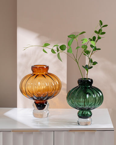 Luna Lantern Vases by Allthingscurated are stylish and versatile. Crafted from high-quality thick glass and creatively shaped like an Oriental Lantern with a strong aesthetic, they are perfect for creative floral arrangement or simply as a decorative display on its own. Comes in 2 sizes and 3 avaliable colors of green, gray and amber.