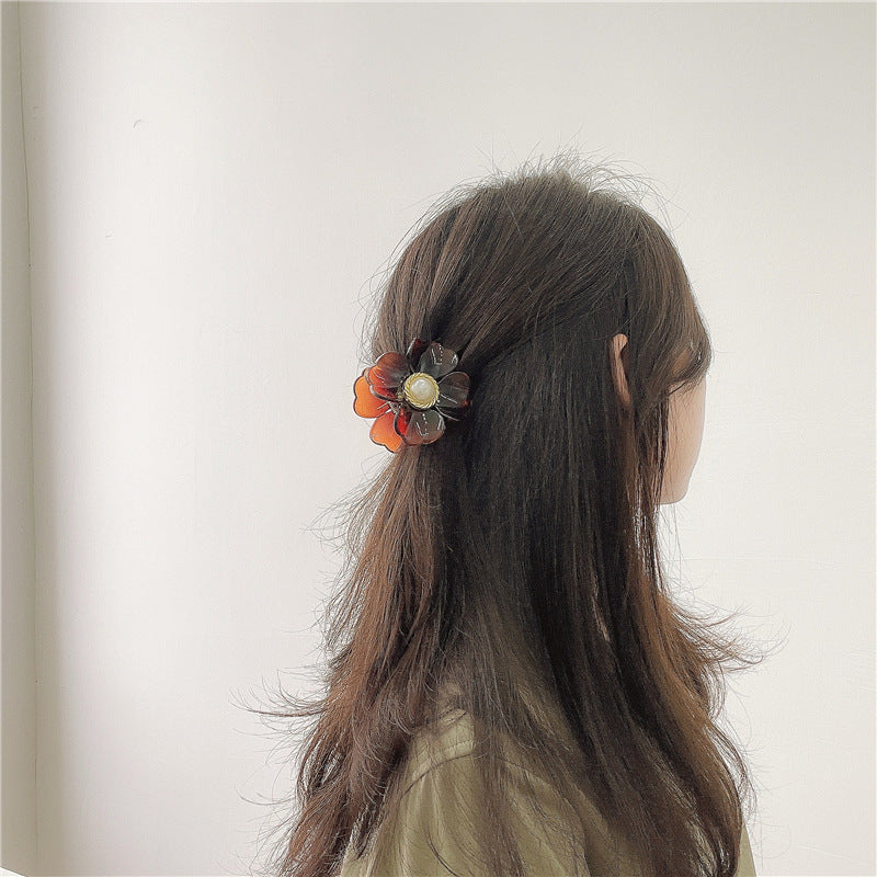 penteado meio preso usando um clipe de garra de flor da Tristar Boutique