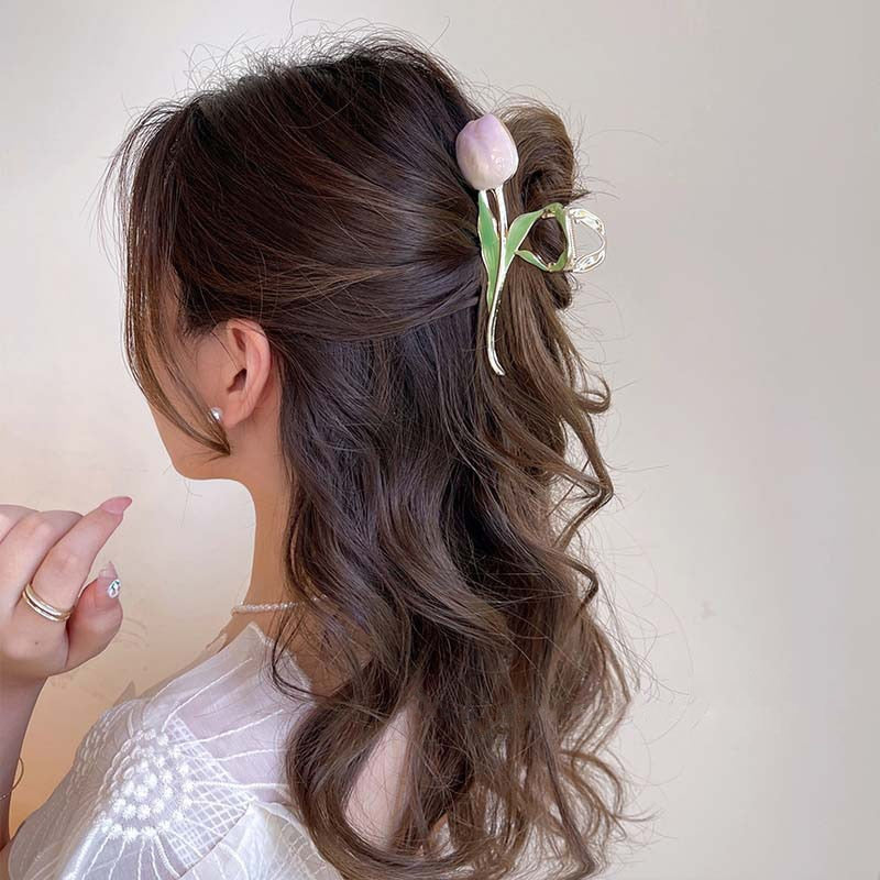  half-up hairstyle using a metal hair claw clip in a shape of a tulip flower
