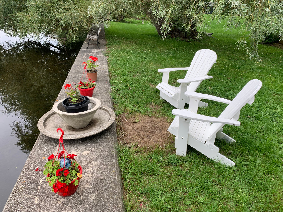 Plastic Adirondack chairs next to a river