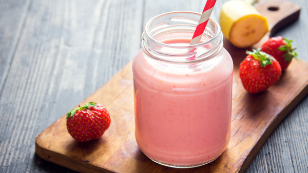 A glass of smoothie made of banana, pineapple, strawberry and apple.