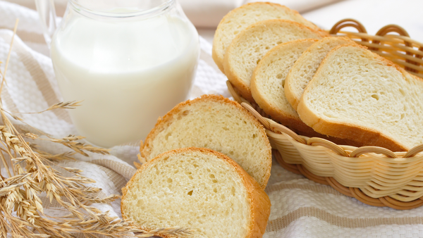 A basket of sliced bread and a pitcher of milk