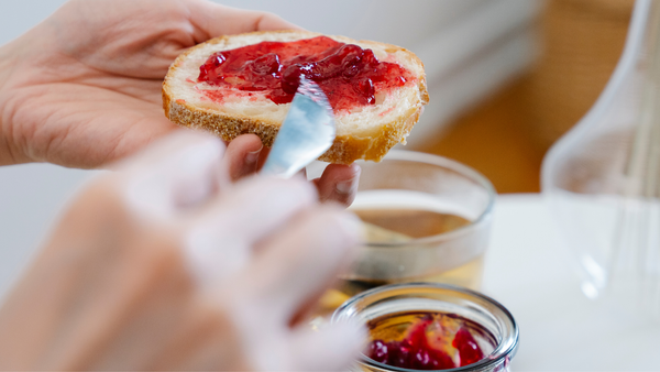 Spreading a jam on a slice of bread