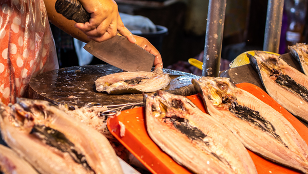 A vendor deboning fresh fish