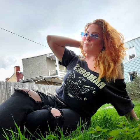 woman in black clothes wearing pink and blue heart sunglasses