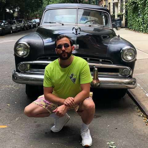 man wearing square metal sunglasses in front of classic car