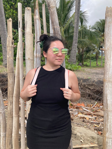 Woman on beach wearing round mirrored sunglasses