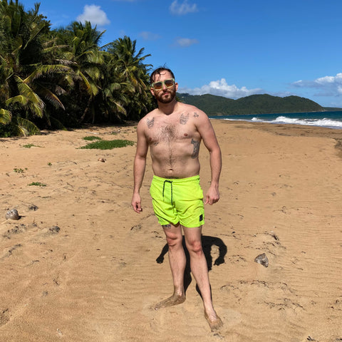 man on beach wearing square sunglasses