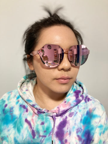 woman wearing tie dye hoodie and round mirrored sunglasses