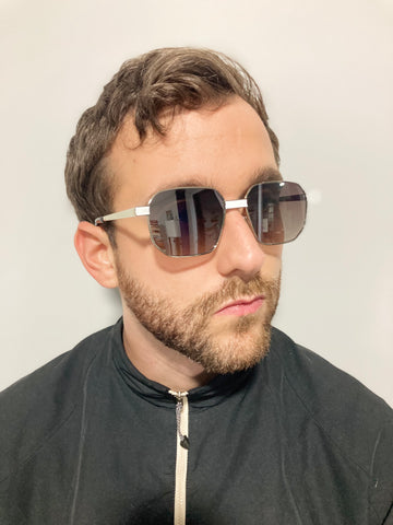 man wearing black track jacket and square sunglasses