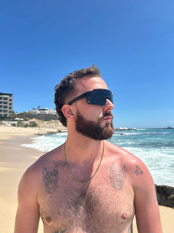 bearded man wearing sport sunglasses on beach