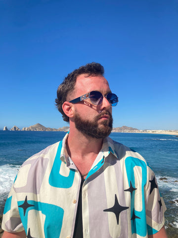 bearded man wearing italian sunglasses on beach