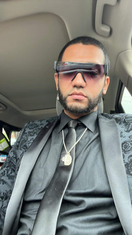 man wearing suit and sunglasses sitting in car