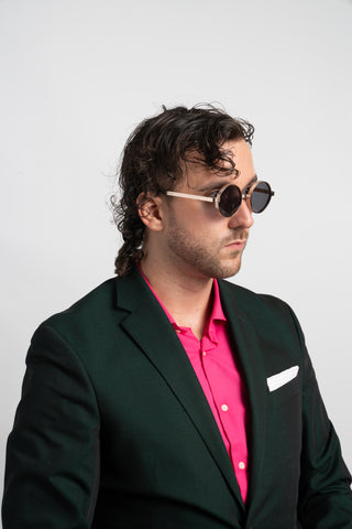 man wearing green and pink suit and round gold steampunk sunglasses