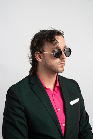 man wearing green suit and round sunglasses with side shield