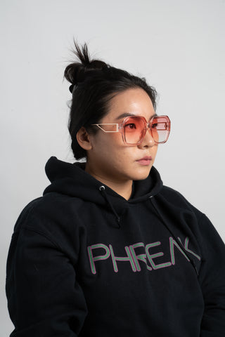 woman wearing black hoodie and pink oversize square sunglasses
