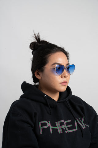 woman wearing black hoodie and blue heart shape sunglasses