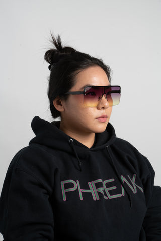 woman wearing black phreak hoodie and purple and yellow shield sunglasses