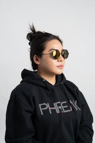 woman wearing black phreak hoodie and round yellow sunglasses