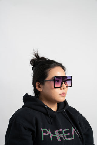 woman wearing black phreak hoodie and square oversize sunglasses