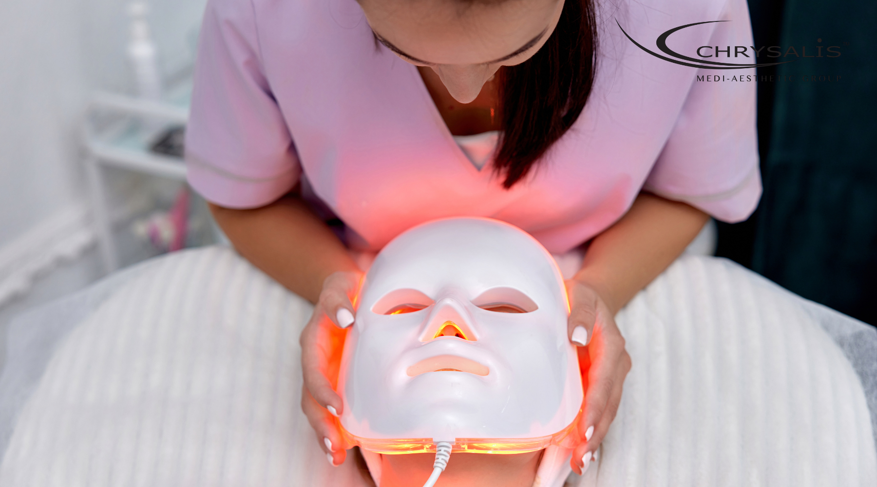 LED facial treatment device glowing gently on a person’s face
