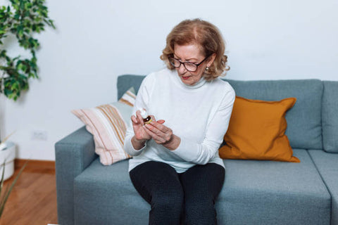 Mujer observando la etiqueta de un gotero de CBD