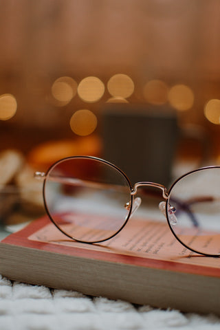 silver framed eyeglasses on a book