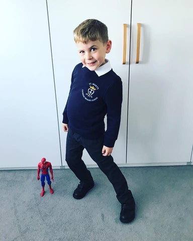 Child wearing school shoes with spiderman figure