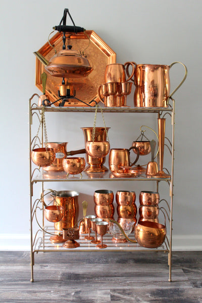 copper decor on brass shelf