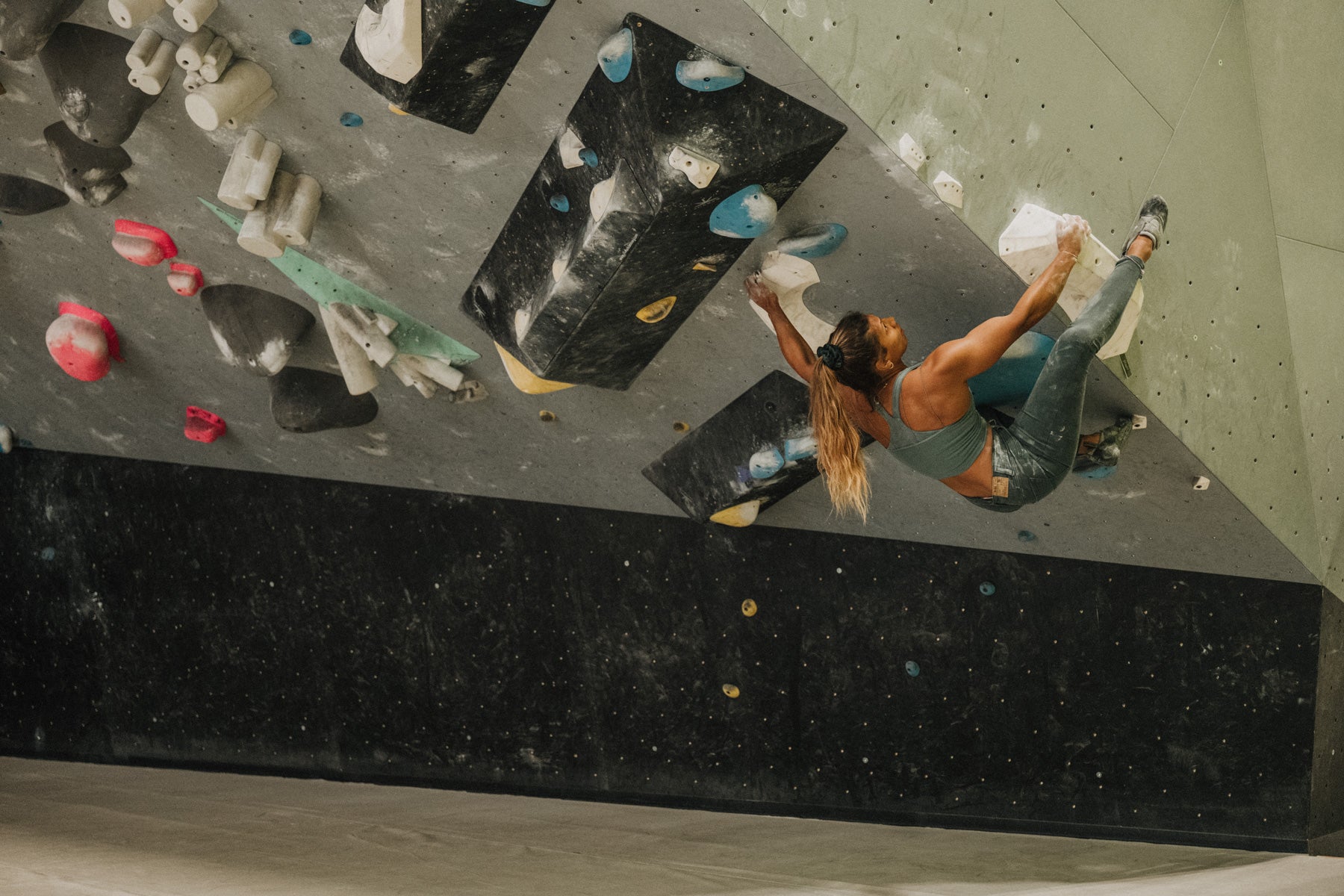 Meagan Martin climbing a bouldering problem at Climb so iLL in the So iLL x Meagan Martin forest denim