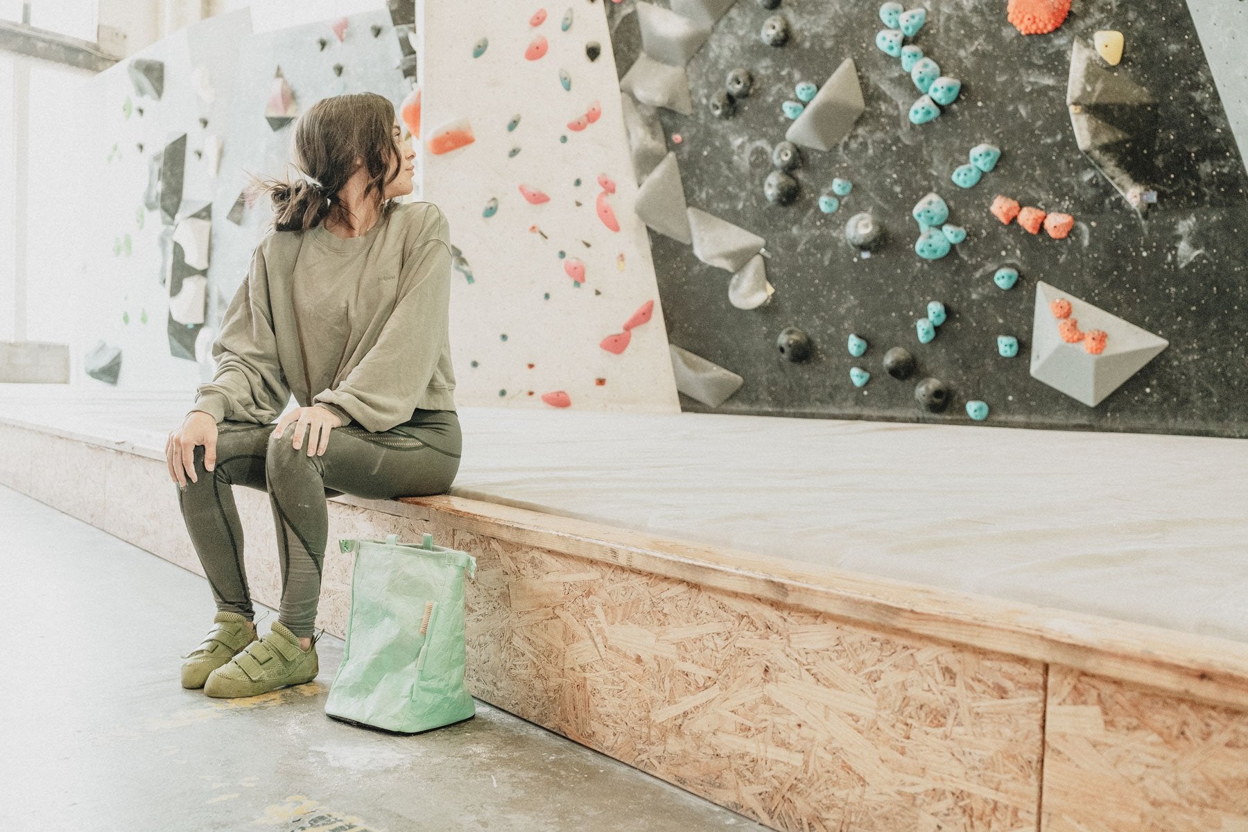 a woman gets ready to climb at climb so ill while using the seafoam tyvek chalk bucket