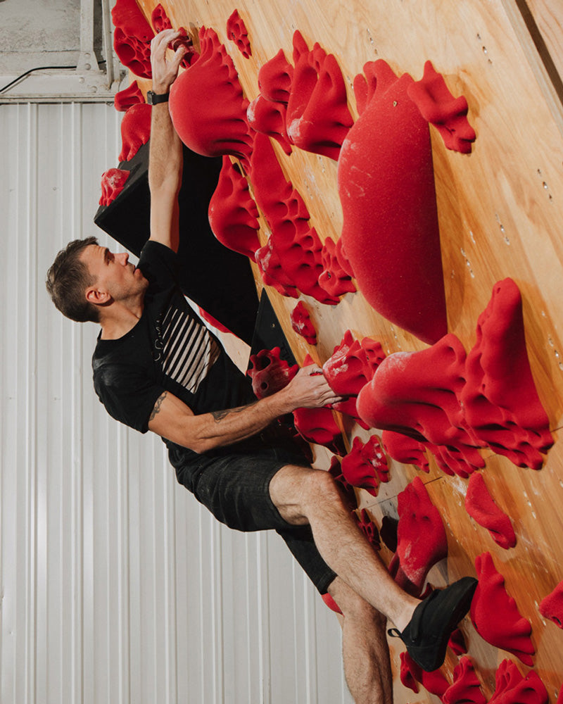 A climber climbs on the so ill fungus family holds after setting the wall